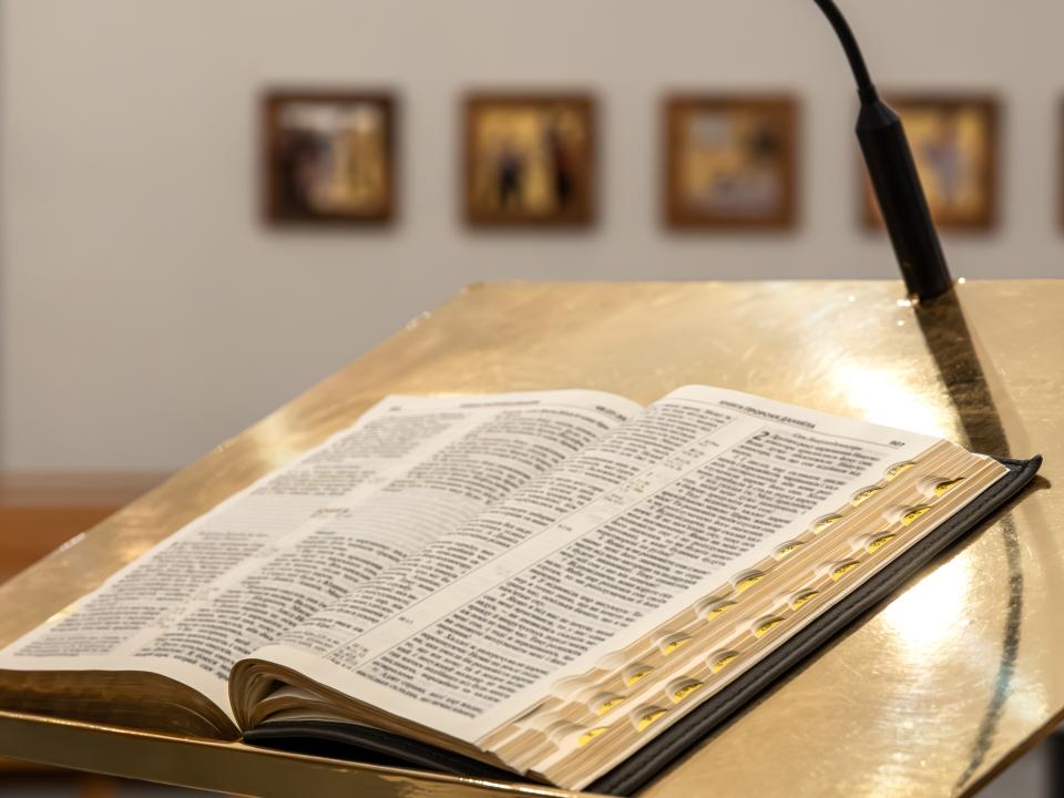 Offene Bibel auf einem Lesepult zum Predigen in einer hellen Kirche