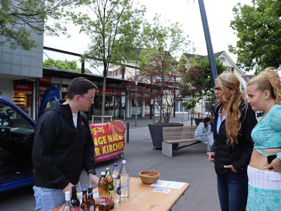 Freiwillige grillen Würste und bieten Getränke an.