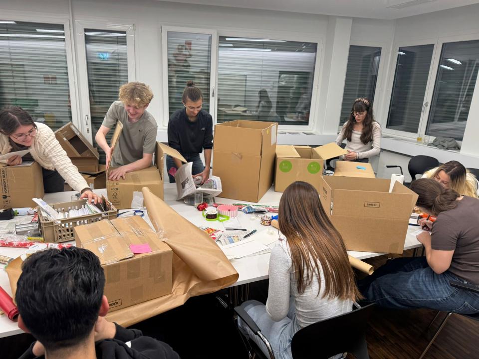 Fleissige Helfer innen beim Einpacken der Päckli