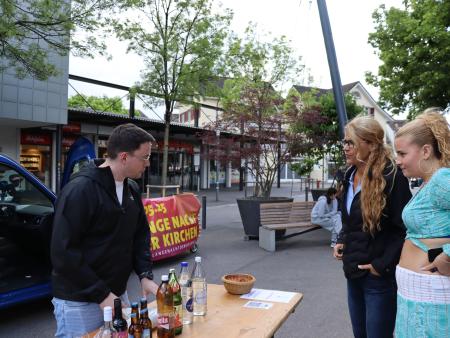 Freiwillige grillen Würste und bieten Getränke an.