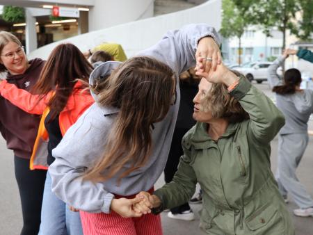 Teilnehmende führen einen fröhlichen Volkstanz auf,