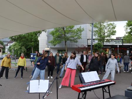 Männer und Frauen in Tracht tanzen im Kreis während der Langen Nacht der Kirchen in Weinfelden.