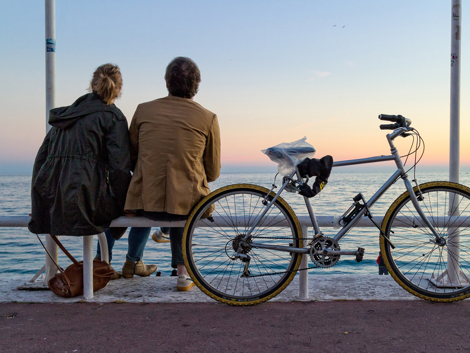 Paar um die 40 geniesst den Sonnenuntergang am Meer